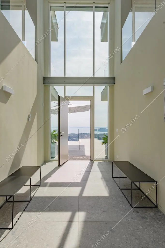 Corridoio con vetrata a tutta parete, vista sul lago e alto soffitto