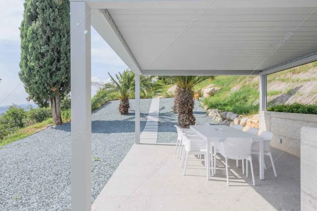 Grande patio con tavolo da pranzo bianco e vista sul lago