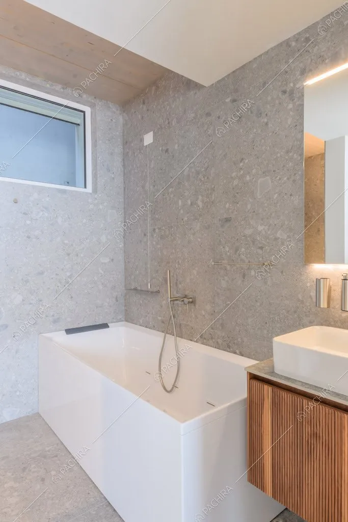 Pavimento e pareti in pietra nel bagno con vasca