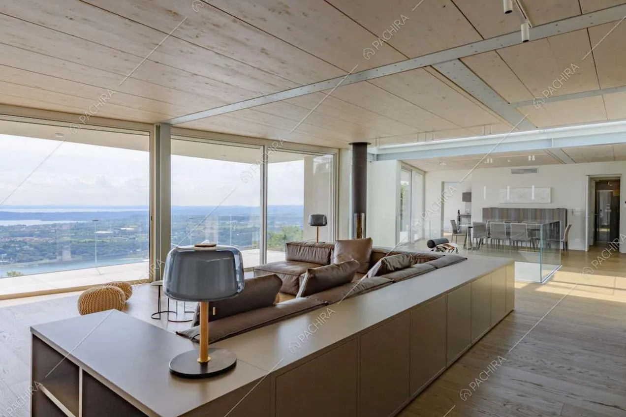 Pavimento in parquet nella sala con soffitto in legno e grandi vetrate