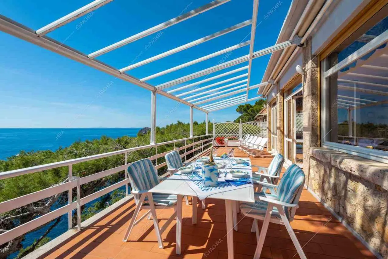 Grande terrazza con tavolo da pranzo bianco e vista sul mare