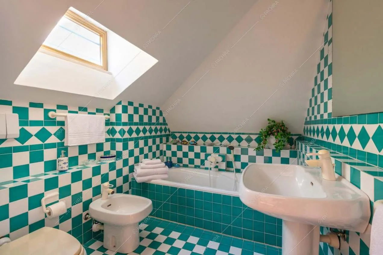 Bagno con vasca e piastrelle bianche e verderame