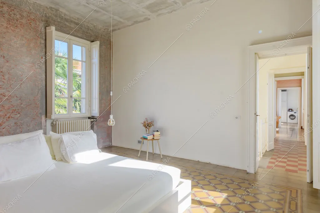 Pavimento in piastrelle a fantasia geometrica e pareti délabré nella camera da letto matrimoniale