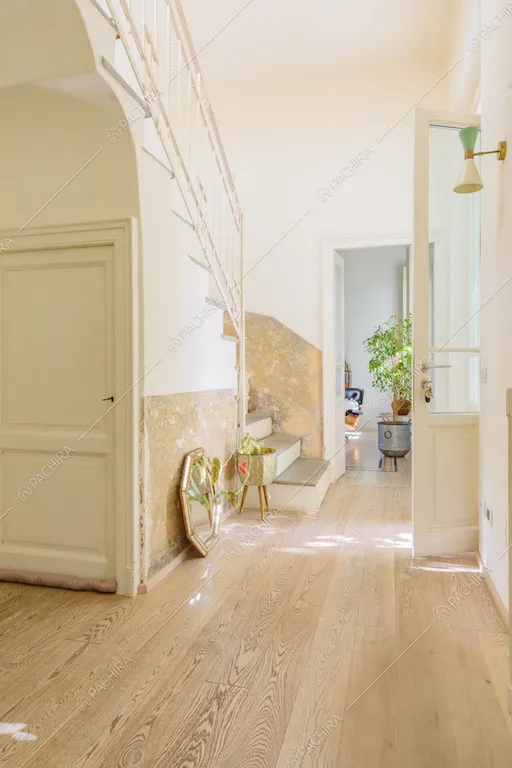 Atrio con pavimento in parquet, pareti bianche e vista sulle scale