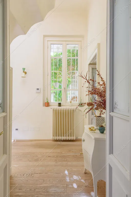 Pavimento in parquet, pareti bianche e finestra