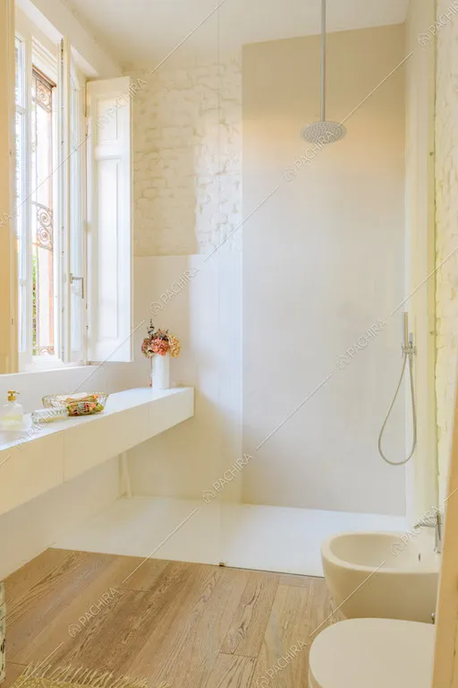 Luminoso bagno con pavimento in parquet e box doccia