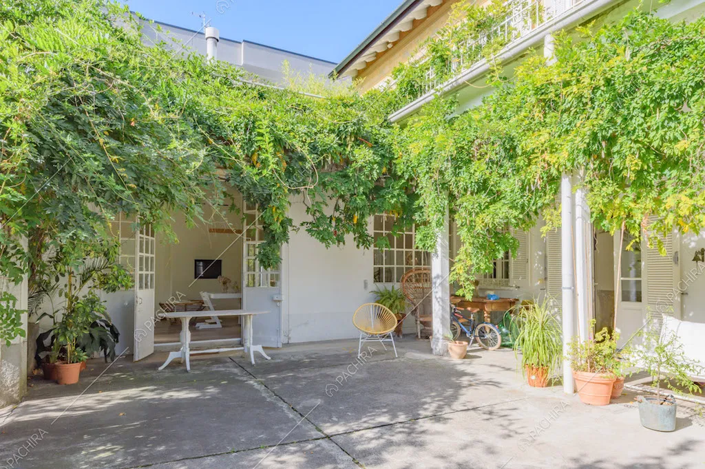 Giardino con portico, piante rampicanti e scorcio sulla zona living