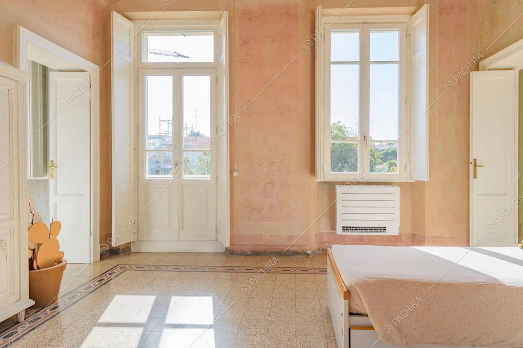 Luminosa camera da letto dei bambini con pareti délabré e porta-finestra bianca