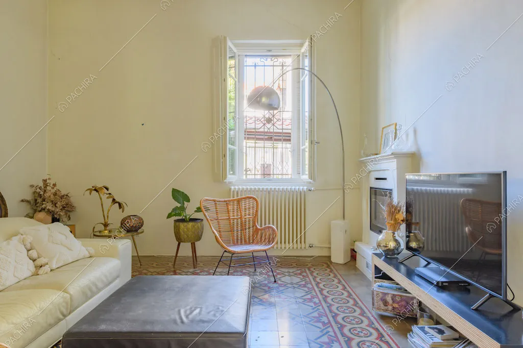 Divano in pelle bianca e pavimento in piastrelle a fantasia geometrica nel salotto