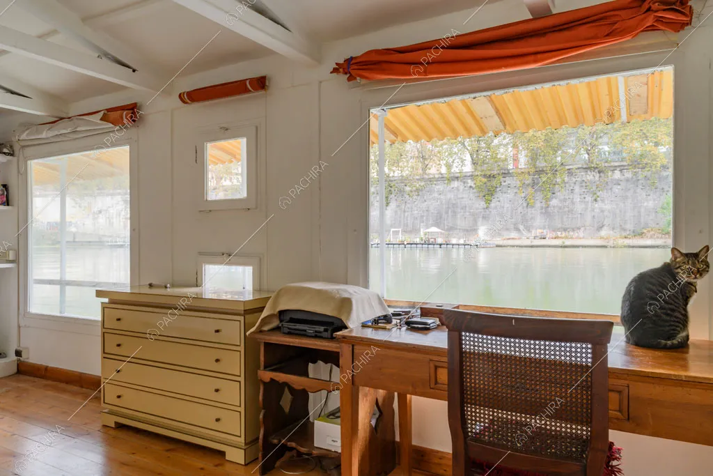 Camera da letto con pavimento in parquet, scrivania in legno e grandi vetrate