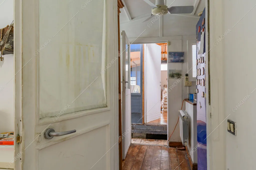 Porta bianca e corridoio con pavimento in parquet
