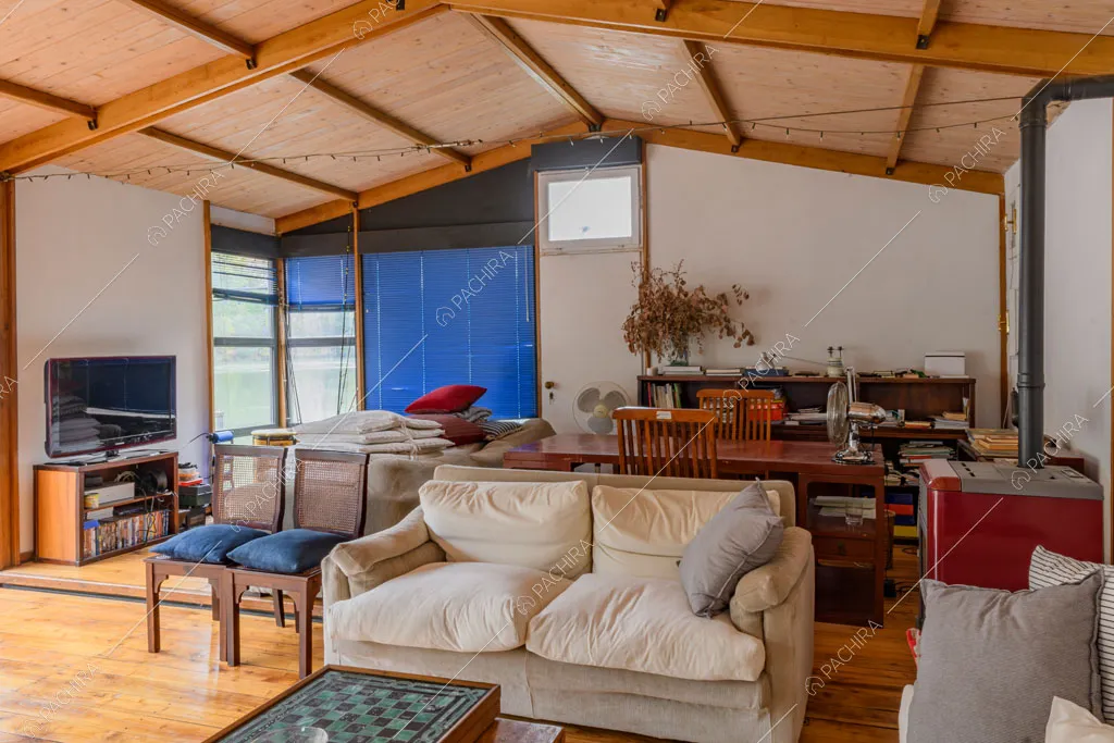Divani nella grande sala con pavimento in parquet e travi in legno sul soffitto