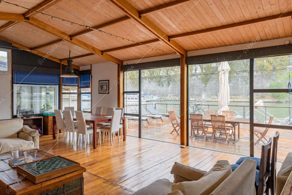 Grande sala con pavimento in parquet, soffitto in travi a vista e grandi vetrate