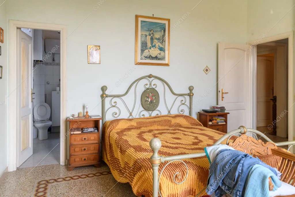 Luminosa camera da letto matrimoniale con pavimento in graniglia e bagno privato