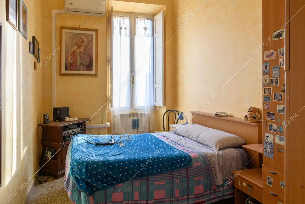 Camera da letto con pareti gialle e pavimento in graniglia
