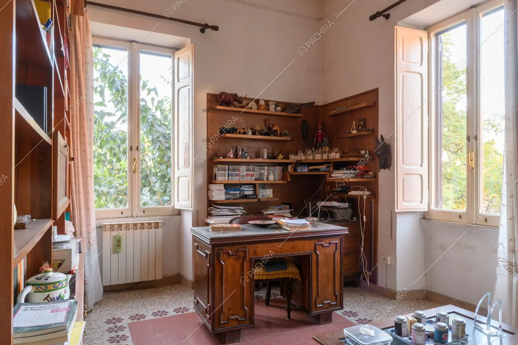 Luminoso studio con scrivania antica e pavimento in graniglia