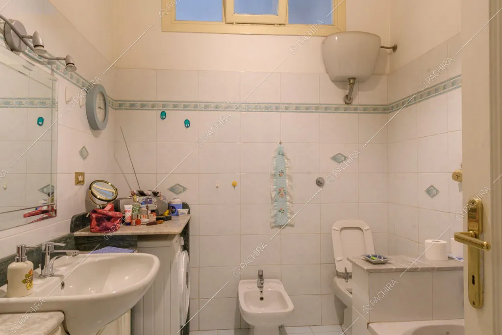 Bagno con piastrelle bianche sulle pareti e vasca