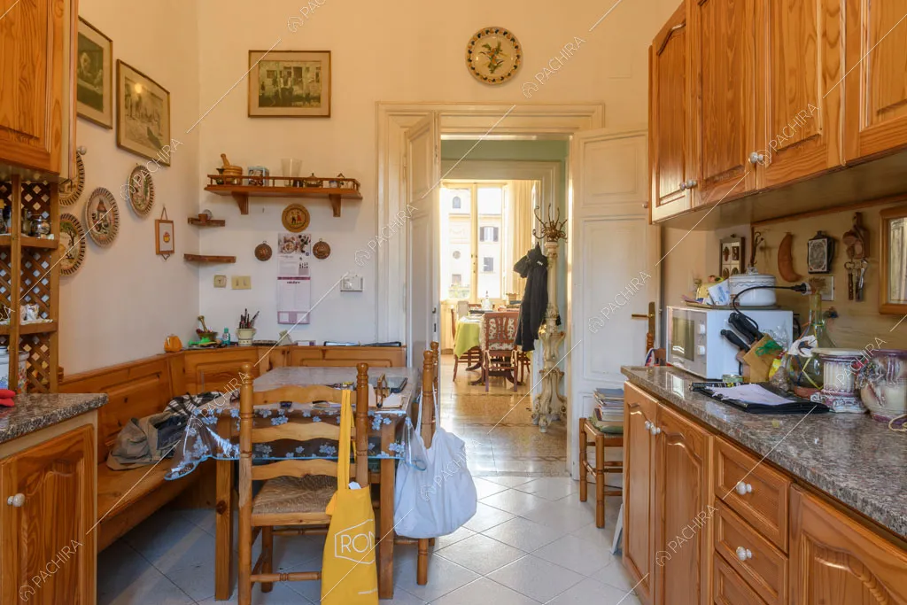 Tavolo da pranzo e panca in legno nella luminosa cucina con piano da lavoro in marmo