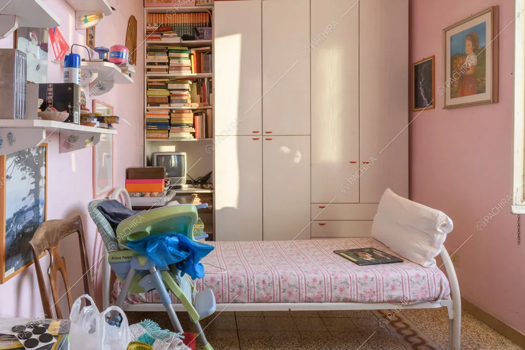 Camera da letto da bambini con pareti rosa e armadio bianco a muro