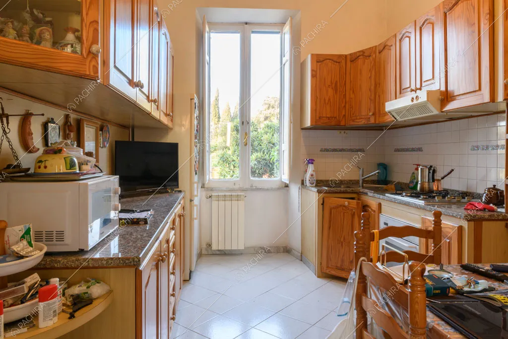 Luminosa cucina in legno con fornelli a gas e paraschizzi in piastrelle bianche