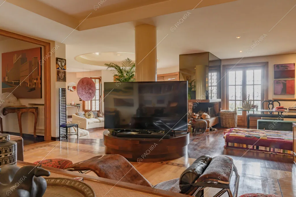 Poltrona di design con vista sulla sala con divano bianco rotondo e camino