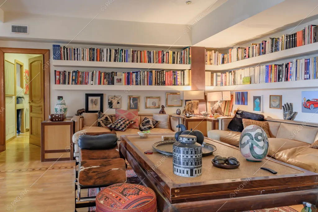 Tavolino nella sala con pavimento in parquet, libreria e divani di pelle