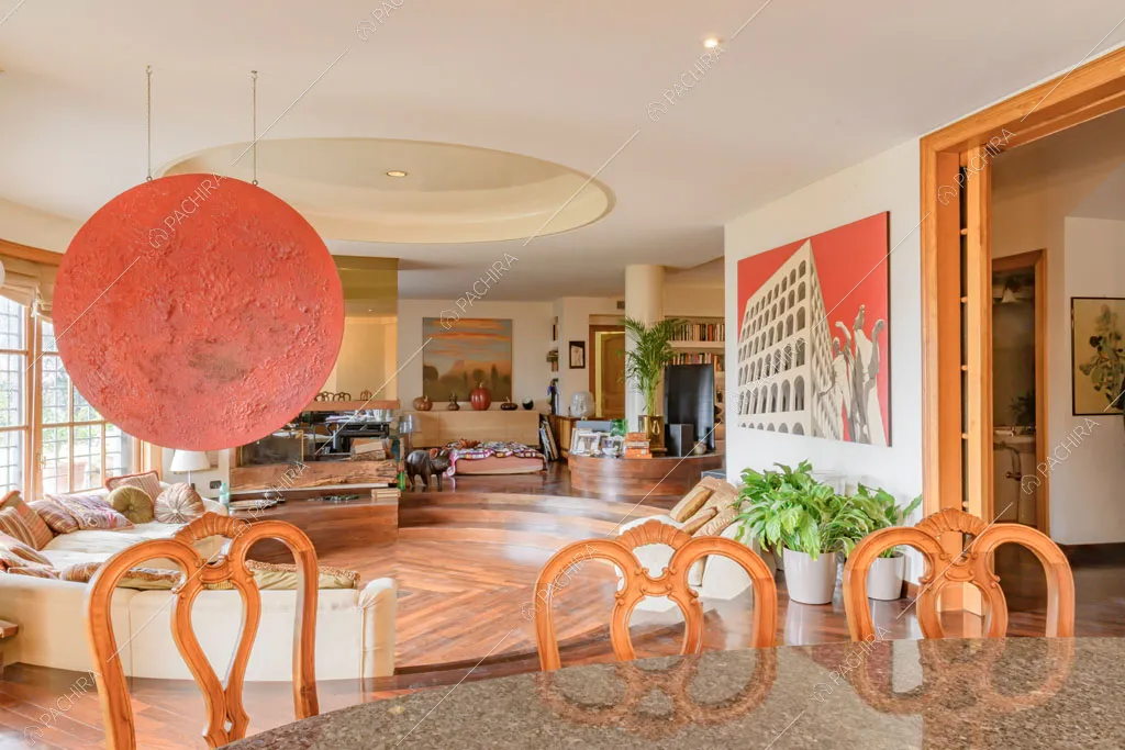 Tavolo da pranzo con sedie di design e vista sul salotto ribassato con pavimento in parquet