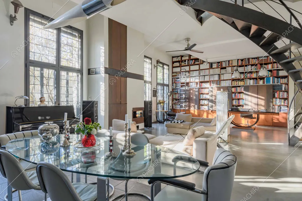 Dal tavolo da pranzo rotondo vista su tutta la zona living e sulla libreria a tutta parete