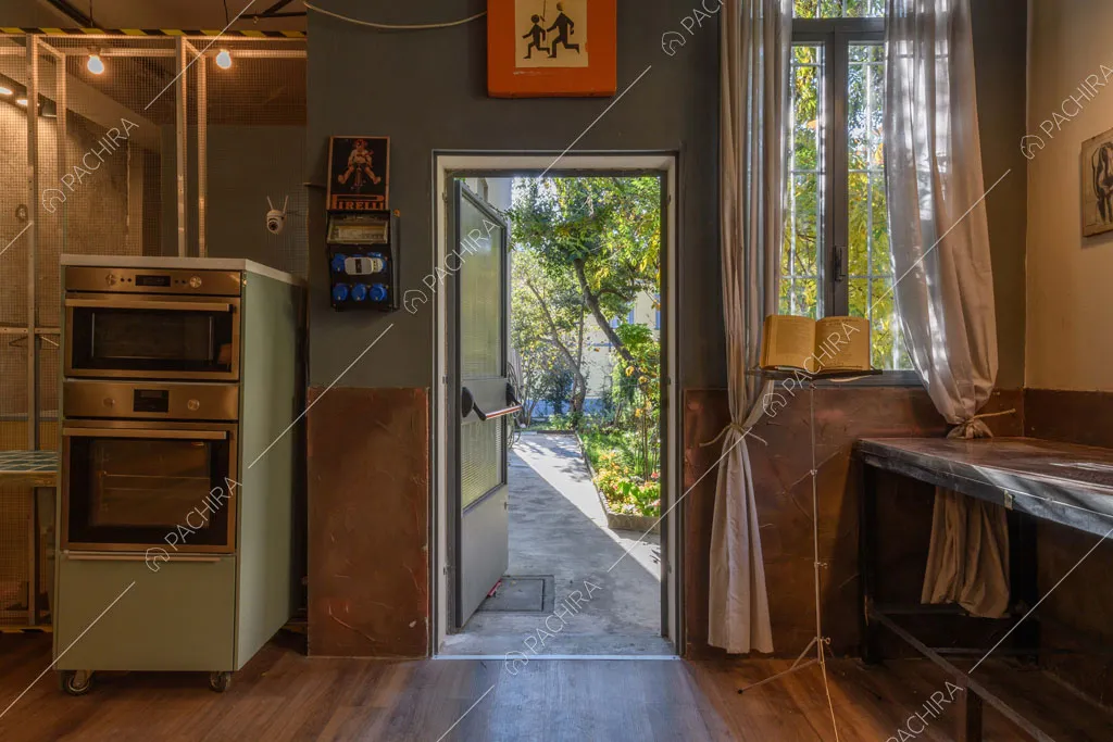 Dalla cucina con pavimento in parquet vista sul cortile tramite la porta d'ingresso