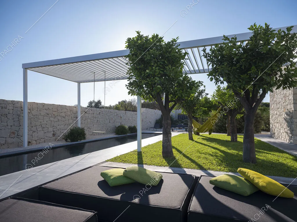 Dai pouf nel giardino vista sugli alberi, sulla piscina e sul patio bianco