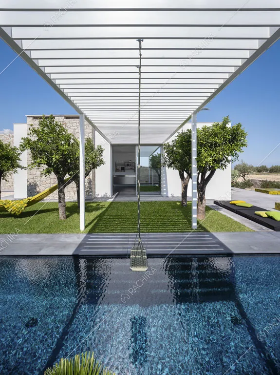 Piscina con altalena sospesa, patio bianco e vista sugli esterni della location