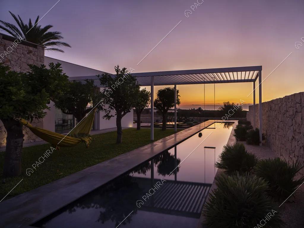 Vista sulla lunga piscina con patio bianco e esterni bianchi