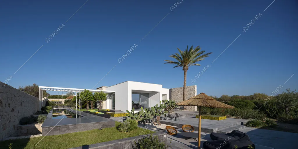 Vista sul grande giardino della location con esterni bianchi, piscina e patio