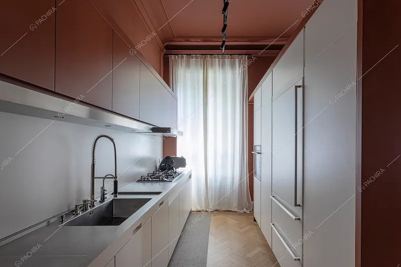 Cucina a parete con pareti e soffitto color terra rossa e pavimento in parquet a spina di pesce