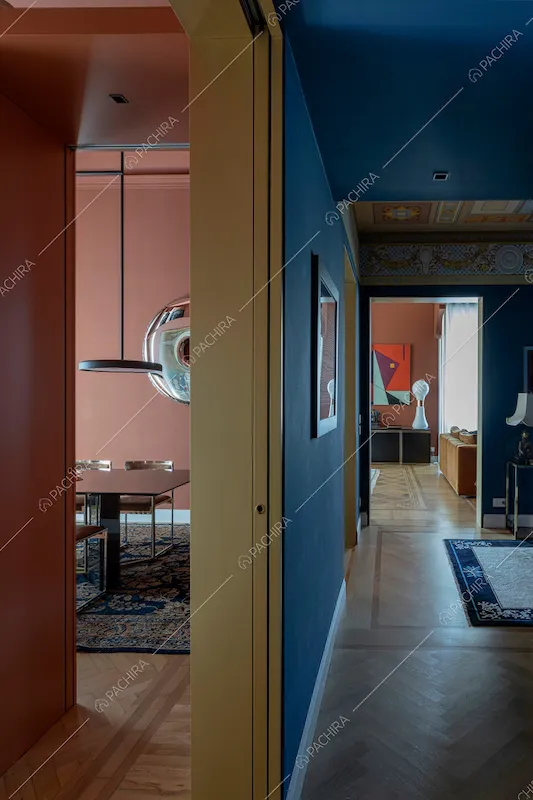 Vista sulla sala da pranzo e sul corridoio con pareti blu e pavimento in parquet