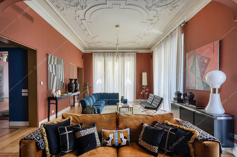 Divano marrone nella zona living con boiserie sul soffitto e grandi vetrate