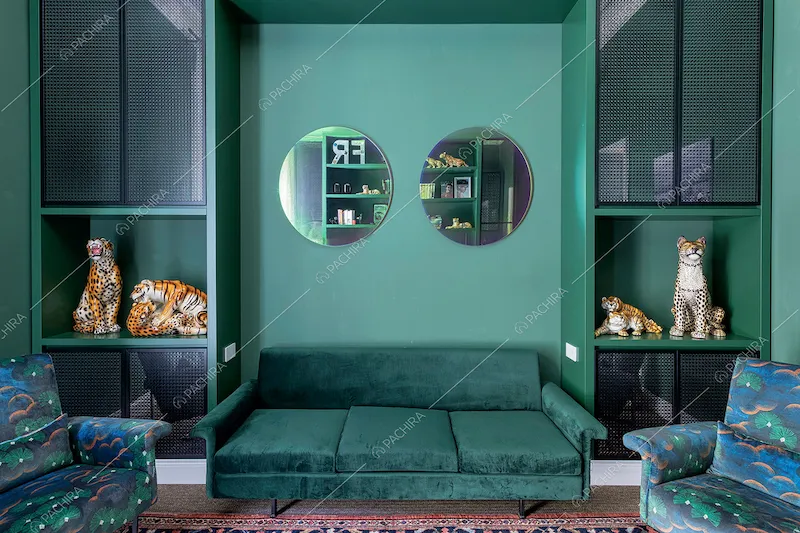 Divanetto in velluto nello studio verde con mobili di design