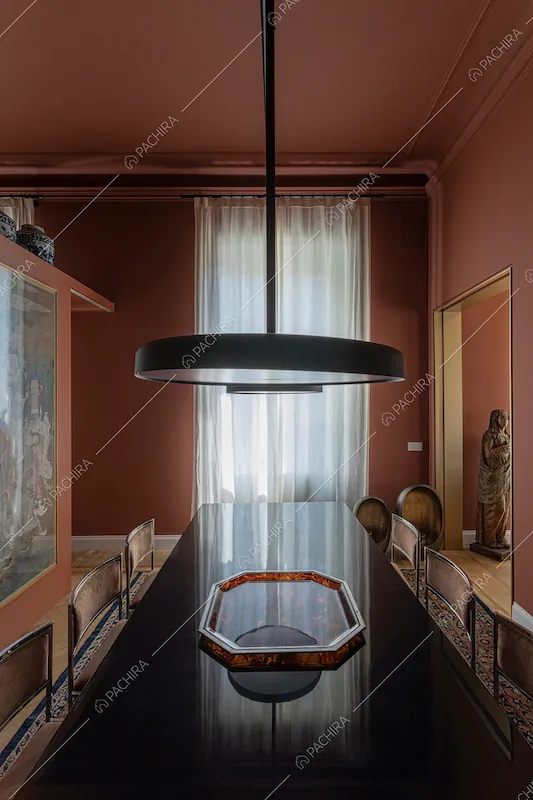 Sala da pranzo con pareti e soffitto color terra rossa e vetrata