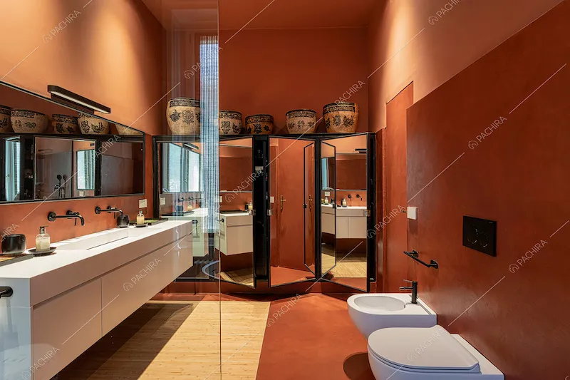 Ampio bagno color terra rossa con box doccia e lungo mobile sospeso