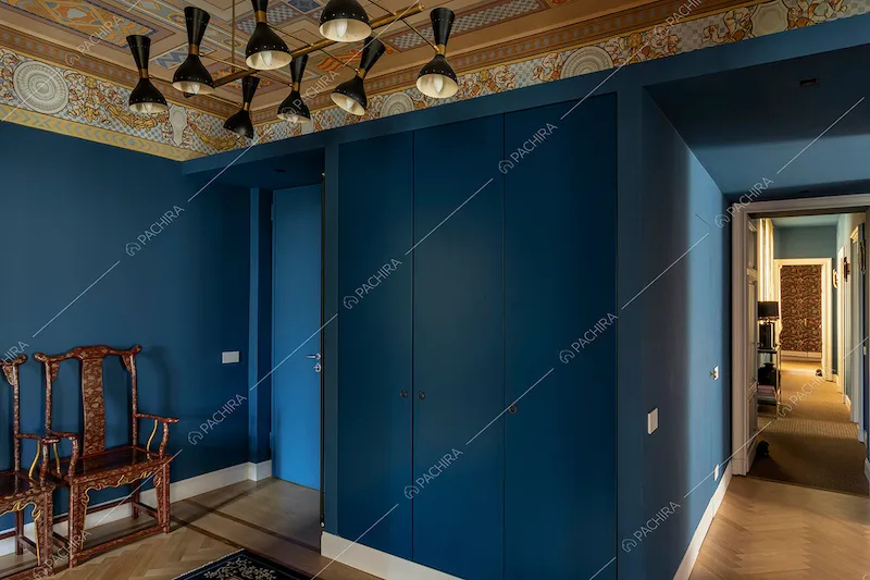 Atrio con pareti blu, soffitto affrescato, sedie antiche e vista sul corridoio