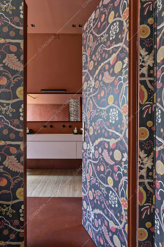 Dal corridoio scorcio sul bagno con pareti, pavimento e soffitto color terra rossa