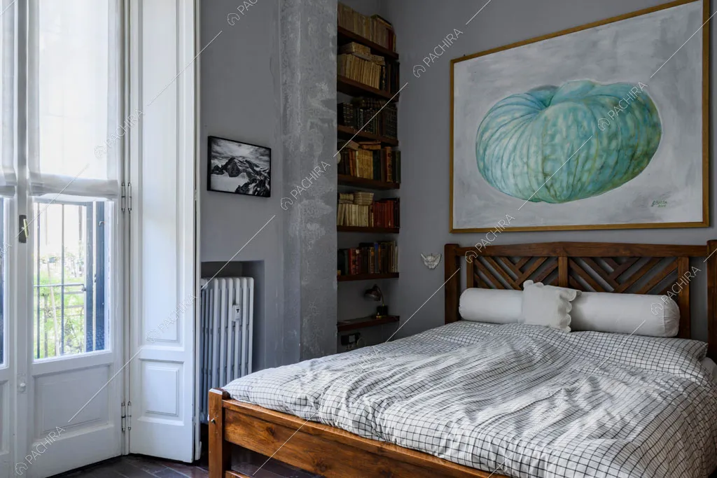 Luminosa camera da letto matrimoniale con boiserie sulla porta-finestra e pareti grigie