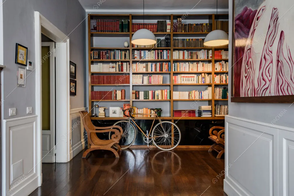 Boiserie sulle pareti della sala da pranzo, libreria, pavimento in parquet e poltrone in legno