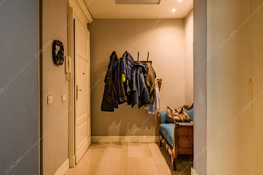 Ingresso con pavimento in parquet e divanetto antico blu
