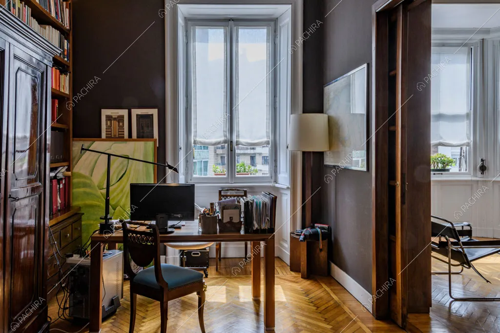 Pavimento in parquet a spina di pesce e libreria antica a parete nello studio