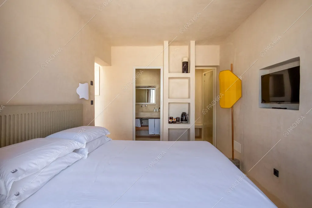 Letto matrimoniale nella camera con bagno privato e lampada di design