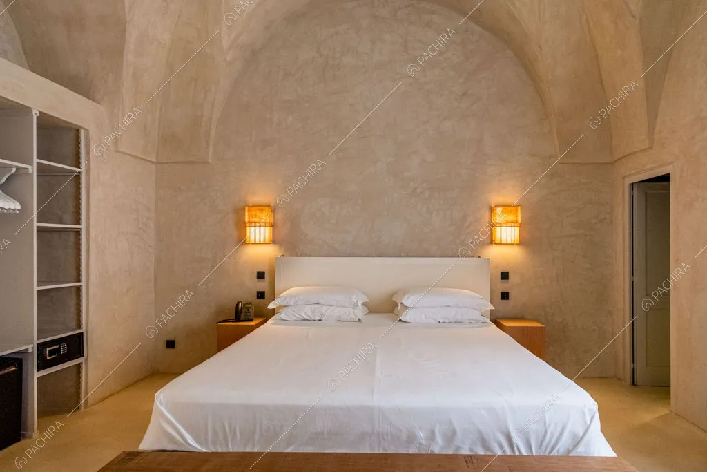 Letto matrimoniale nella grande camera con sofitto a volta e armadio costruito nel muro
