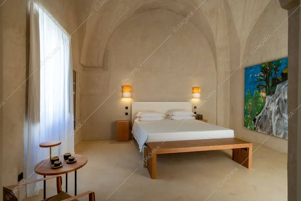 Panca in legno nella camera da letto con quadro, vetrata e volte sul soffitto