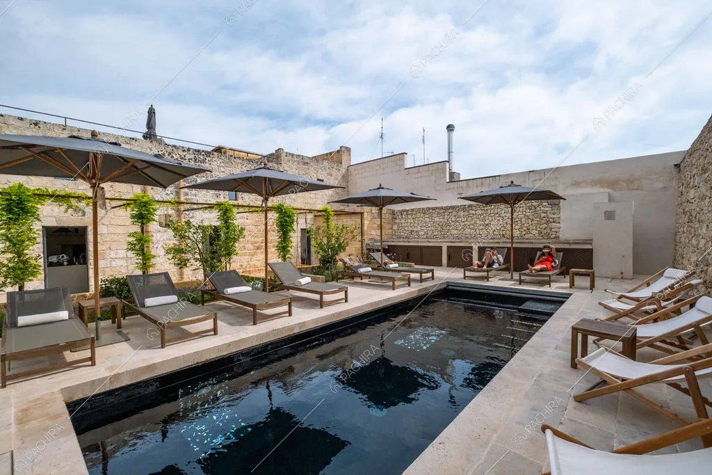 Piscina con numerose sdraio e lettini nel giardino della location