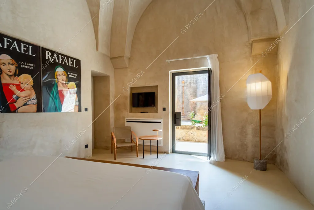 Camera da letto matrimoniale con poster e porta-finestra con vista sul giardino